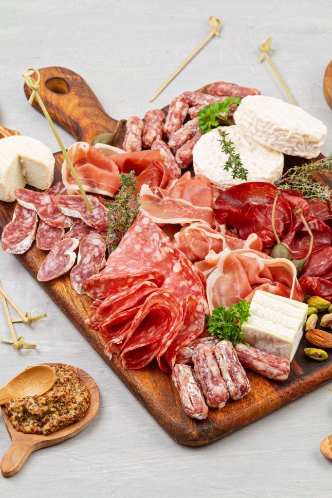 Appetizers table with differents antipasti, charcuterie, snacks and wine. Sausage, ham, tapas