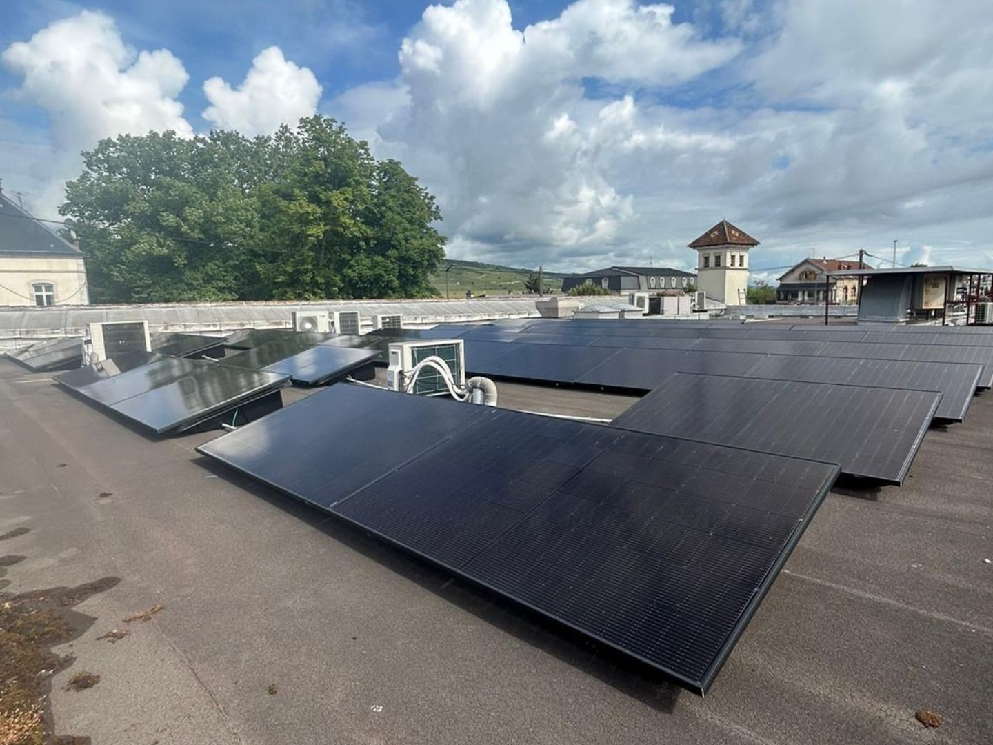 Installation photovoltaïque — Toiture-terrasse, vue village, réalisation Protec Energy en Rhône-Alpes