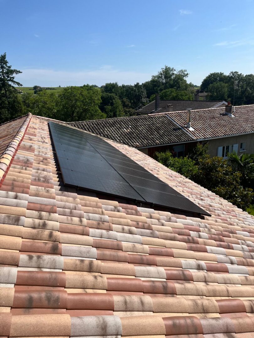Installation photovoltaïque — Toiture tuiles, village en fond, réalisation Protec Energy en Rhône-Alpes