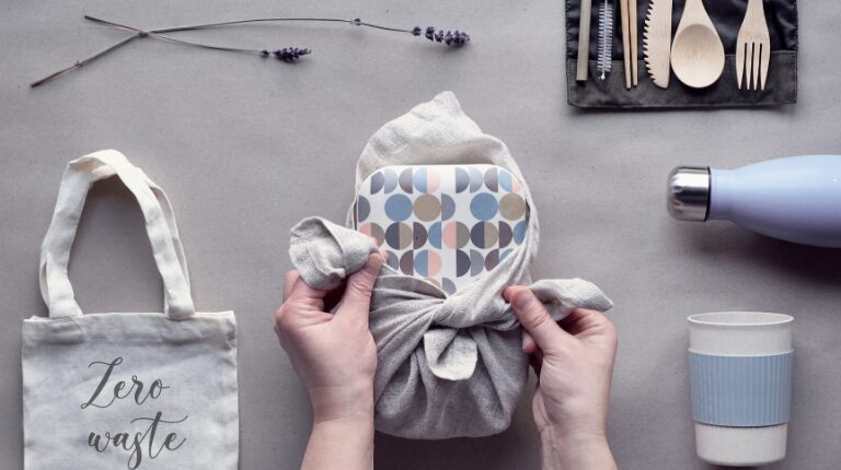 Idées de kit zéro déchet pour vos cadeaux de noël. Sur la photo, un verre, une bouteille, un tote bag et un tupperware réutilisable.